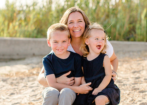 Woman with two children sitting on a sandy beach